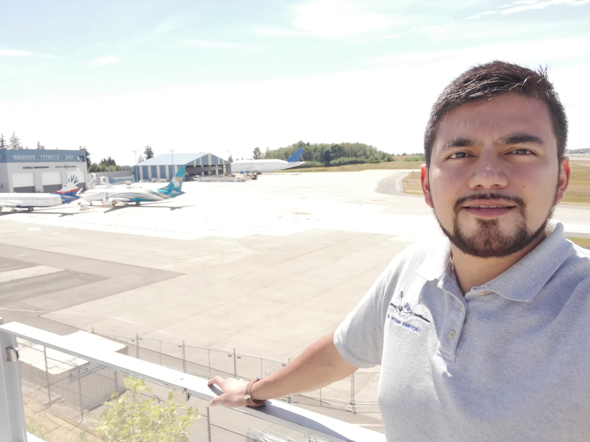 David is stood on a balcony overlooking runway with parked planes